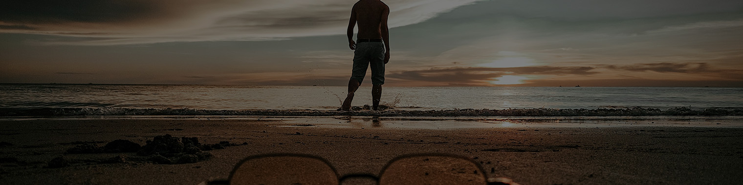 Man on a beach with glasses